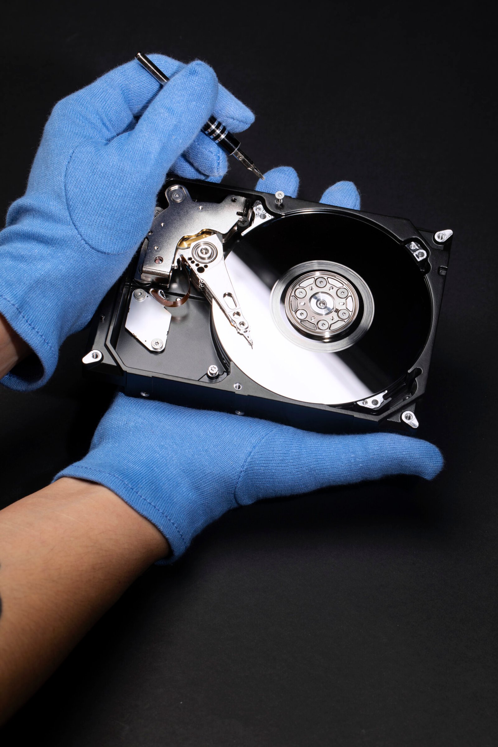 hands-with-gloves-repairing-hard-drive-high-angle hands-with-gloves-repairing-hard-drive-high-angle